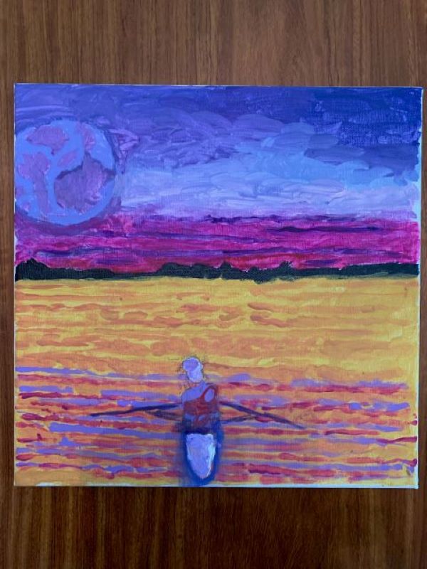 A man rowing on a kayak in the sunset